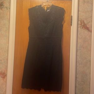 Black lacy mini dress, cutout in midsection. High neck sleeveless exposed zipper